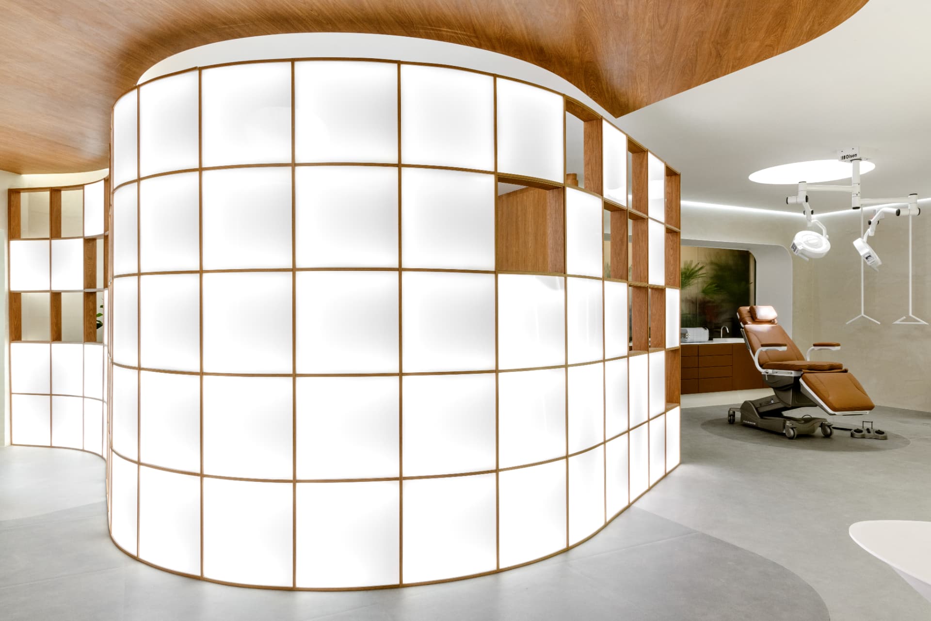 Ambiente corporativo com parede curva iluminada em marcenaria de madeira nobre