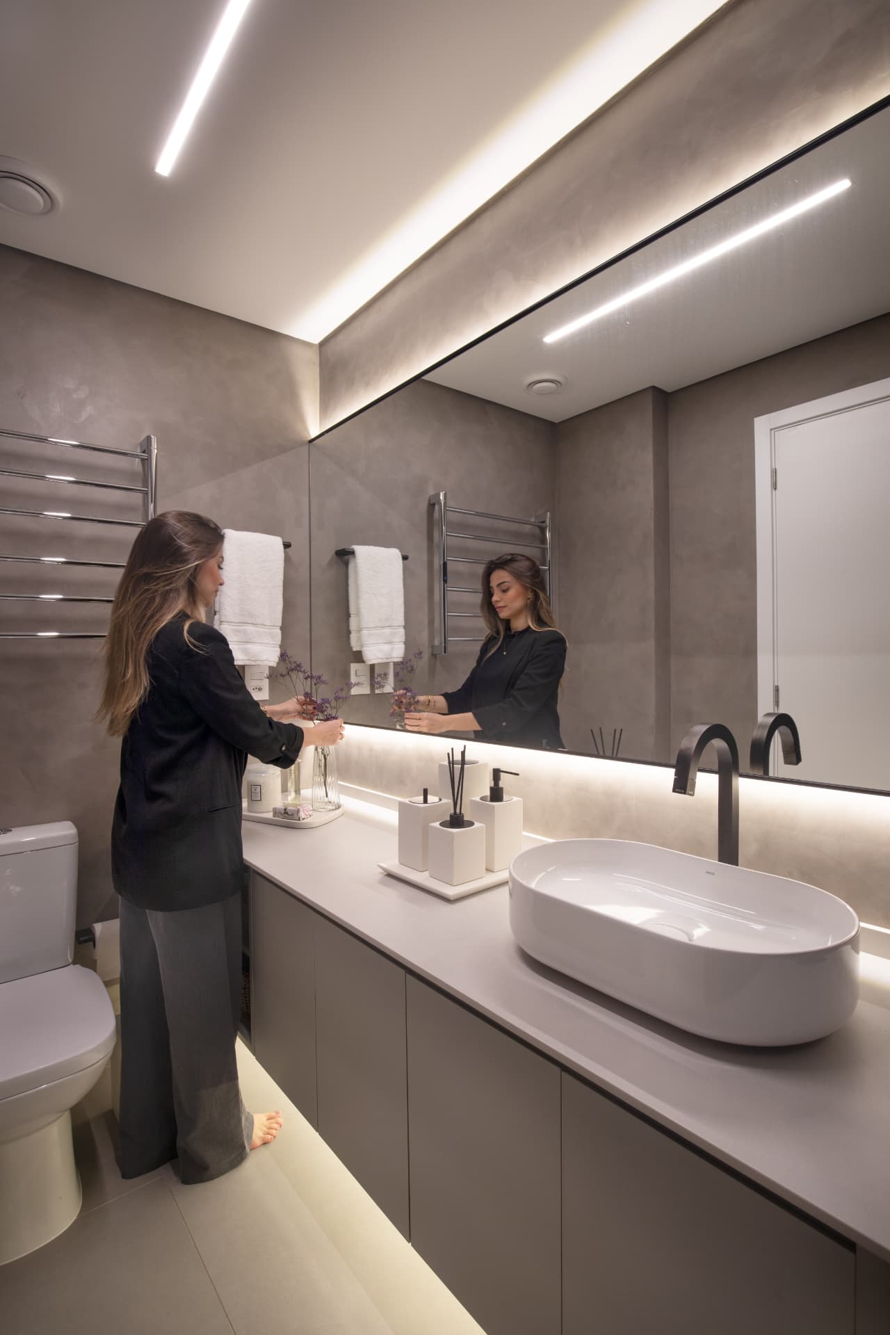 Lavabo com bancada sob medida, iluminação linear e espelho amplo